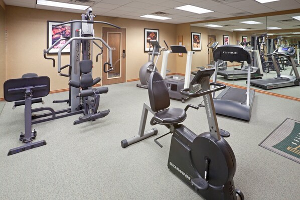 A gym with various exercise equipment including treadmills, elliptical machines, and weight machines.