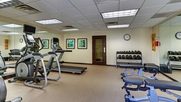A gym with treadmills, an elliptical, and weight machines.