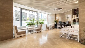 A modern lobby with a curved ceiling, seating area with sofas and chairs, a reception desk, and large windows offering a view of the outside. - New Seoul Hotel (Seoul)