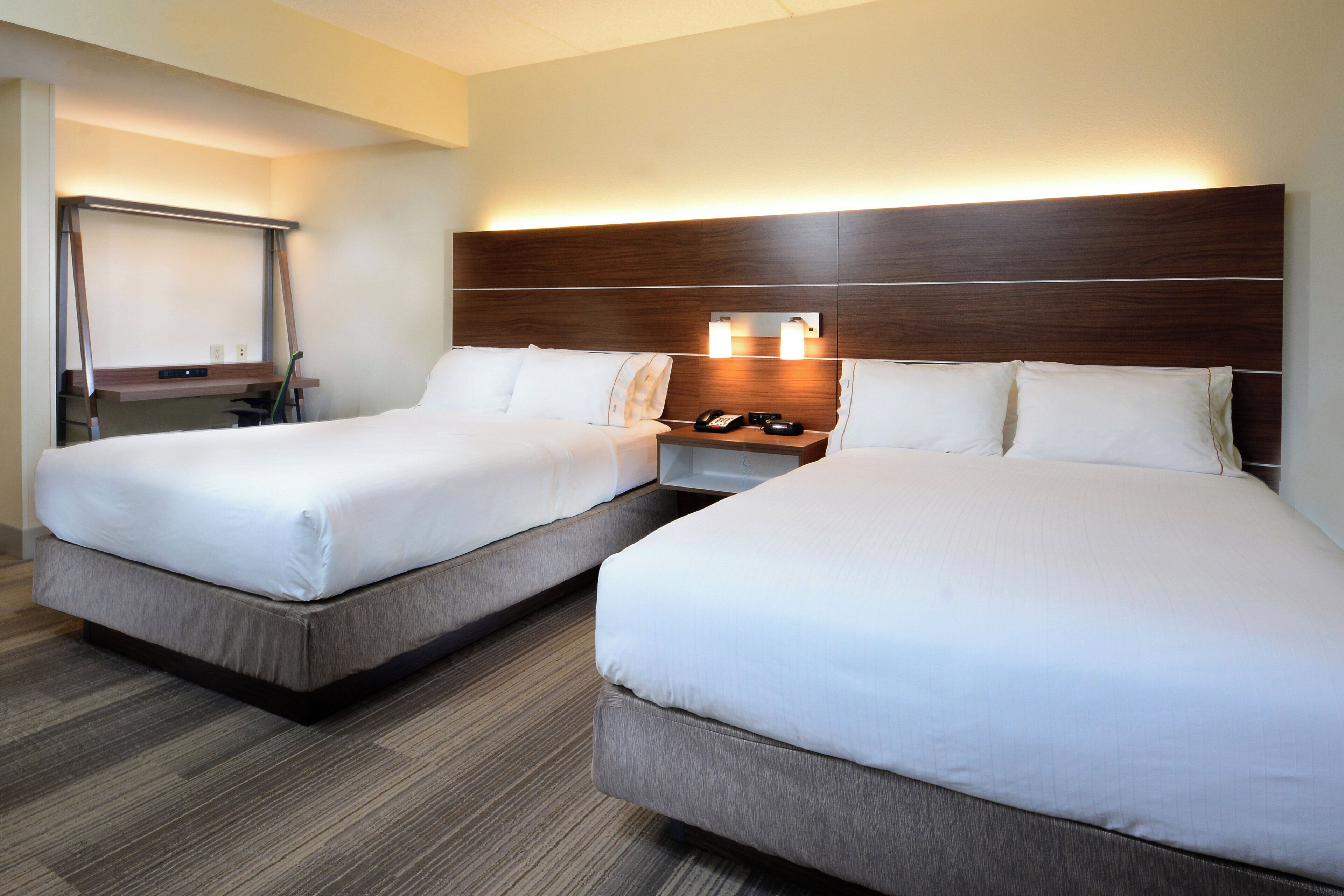 Ein Hotelzimmer mit zwei Betten, einem Schreibtisch und einem Sessel.