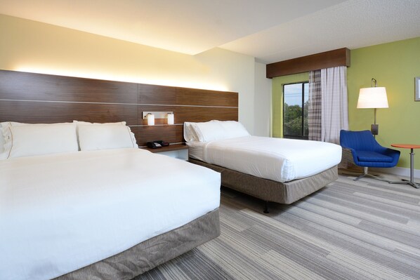 A hotel room with two beds, a nightstand, a lamp, a chair, and a small table. - Holiday Inn Express & Suites Raleigh Durham Airport at RTP by IHG (Durham)