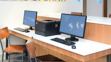 Taulell de recepció amb dos monitors, una impressora i un teclat.