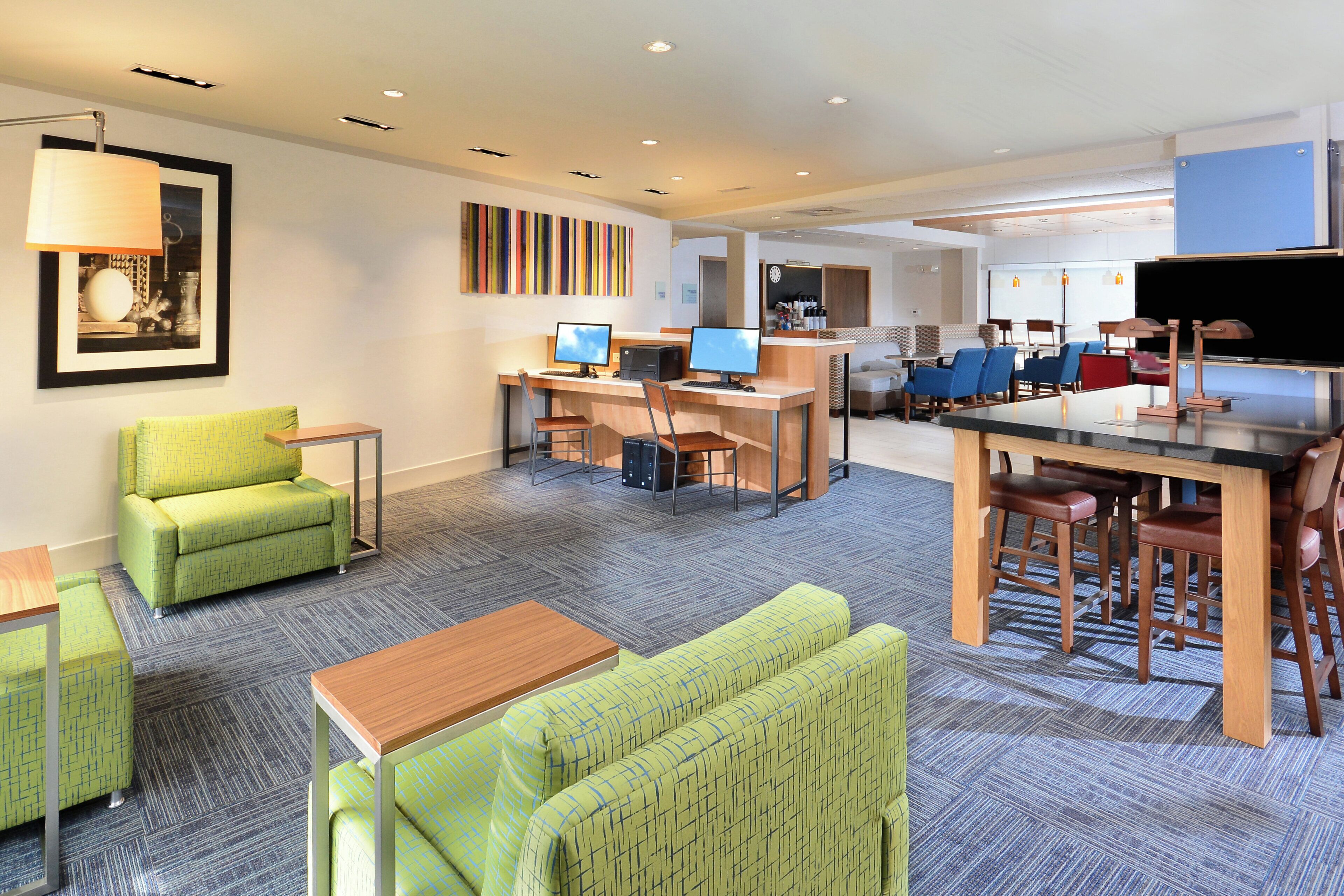 A hotel lobby with seating areas, a reception desk, and a bar.