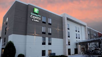 Edificio de un hotel Holiday Inn Express & Suites con diseño moderno, destacando un logo verde y un techo plano.