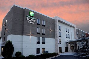 A Holiday Inn Express & Suites hotel building with a modern design, featuring a prominent green logo and a flat roof. - Holiday Inn Express & Suites Raleigh Durham Airport at RTP by IHG (Durham)