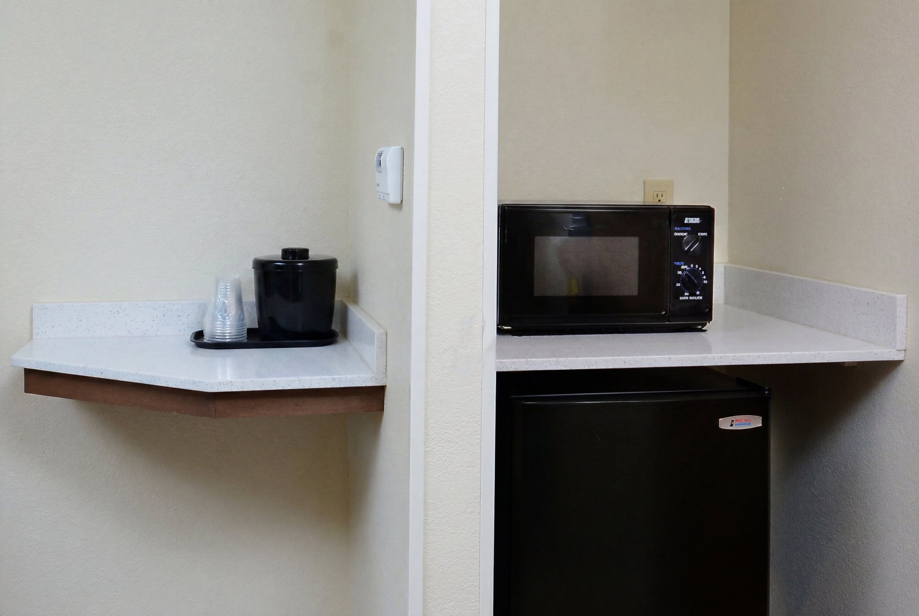A kitchenette with a microwave, a coffee maker, and a small refrigerator.