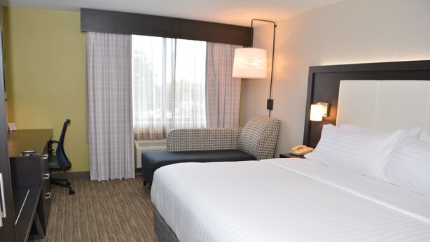 A hotel room with a large bed, a desk with a chair, a small couch, and a lamp. - Holiday Inn Express & Suites Waterville - North by IHG (Waterville)