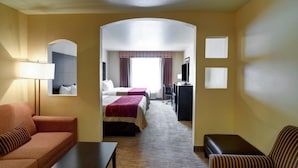A hotel room with a sofa, a bed, a desk, and a television.