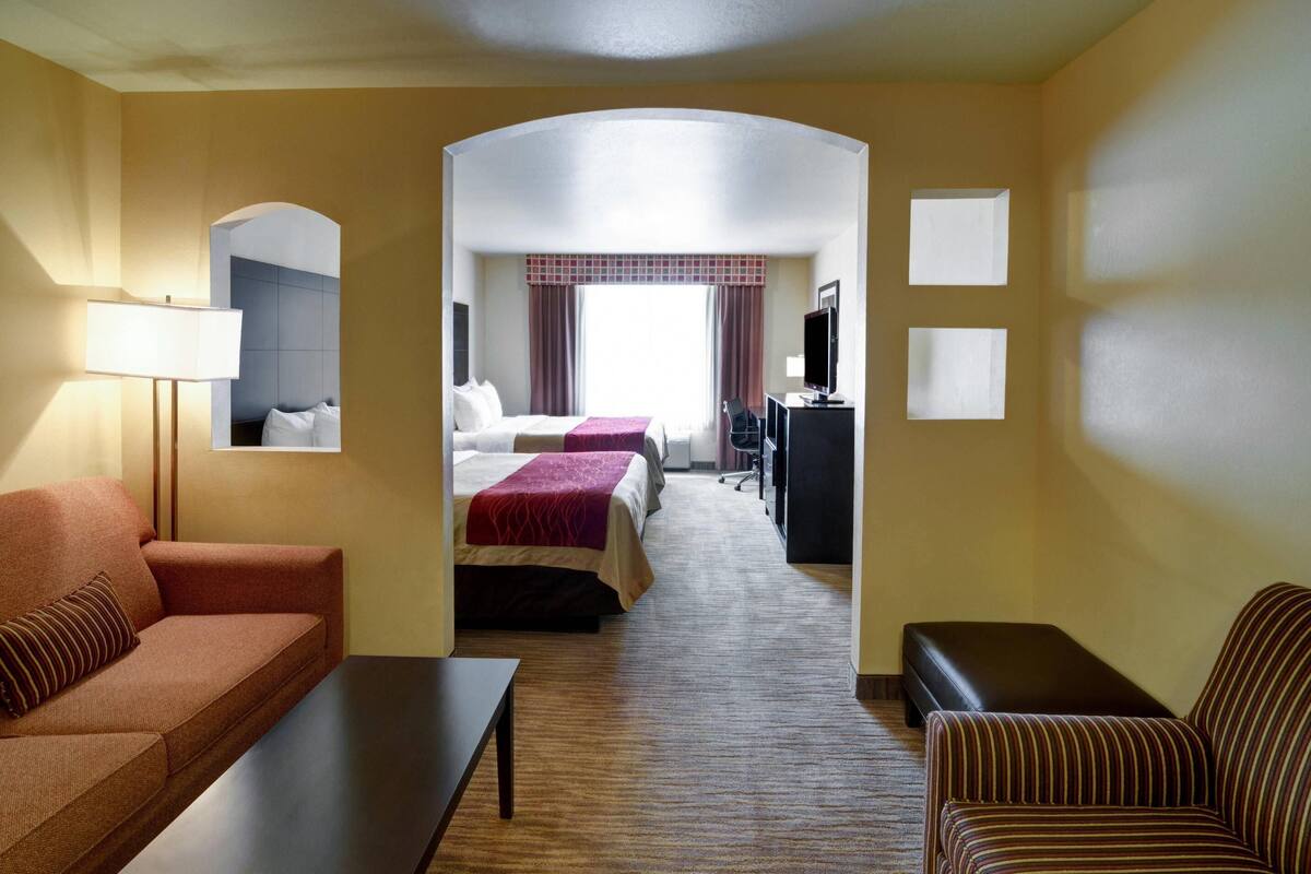 Una habitación de hotel con sofá, cama, escritorio y televisor.