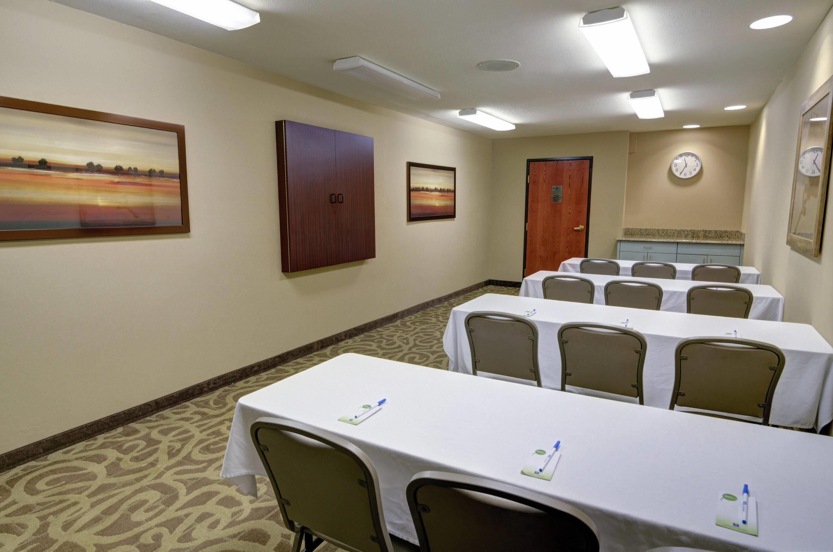 A conference room with tables, chairs, and artwork on the walls.