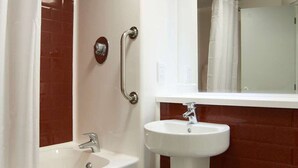 Ein modernes Badezimmer mit einer weißen Badewanne, einem Waschbecken und einer Toilette.