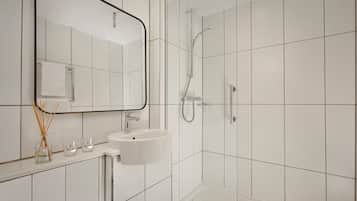 A modern bathroom with a white sink, mirror, and shower.