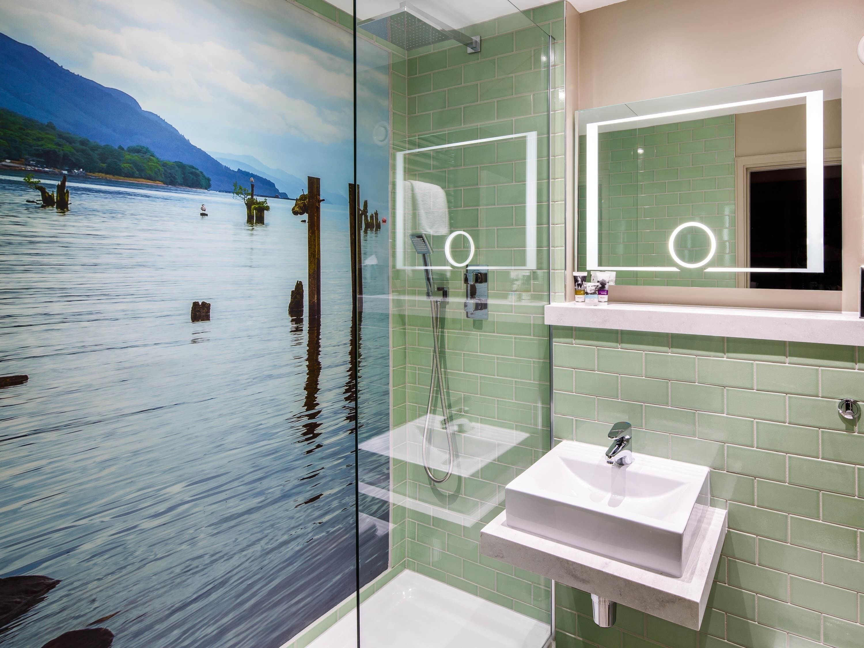 A bathroom with a glass partition, a sink, and a mirror.