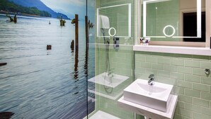 A bathroom with a glass partition, a sink, and a mirror.