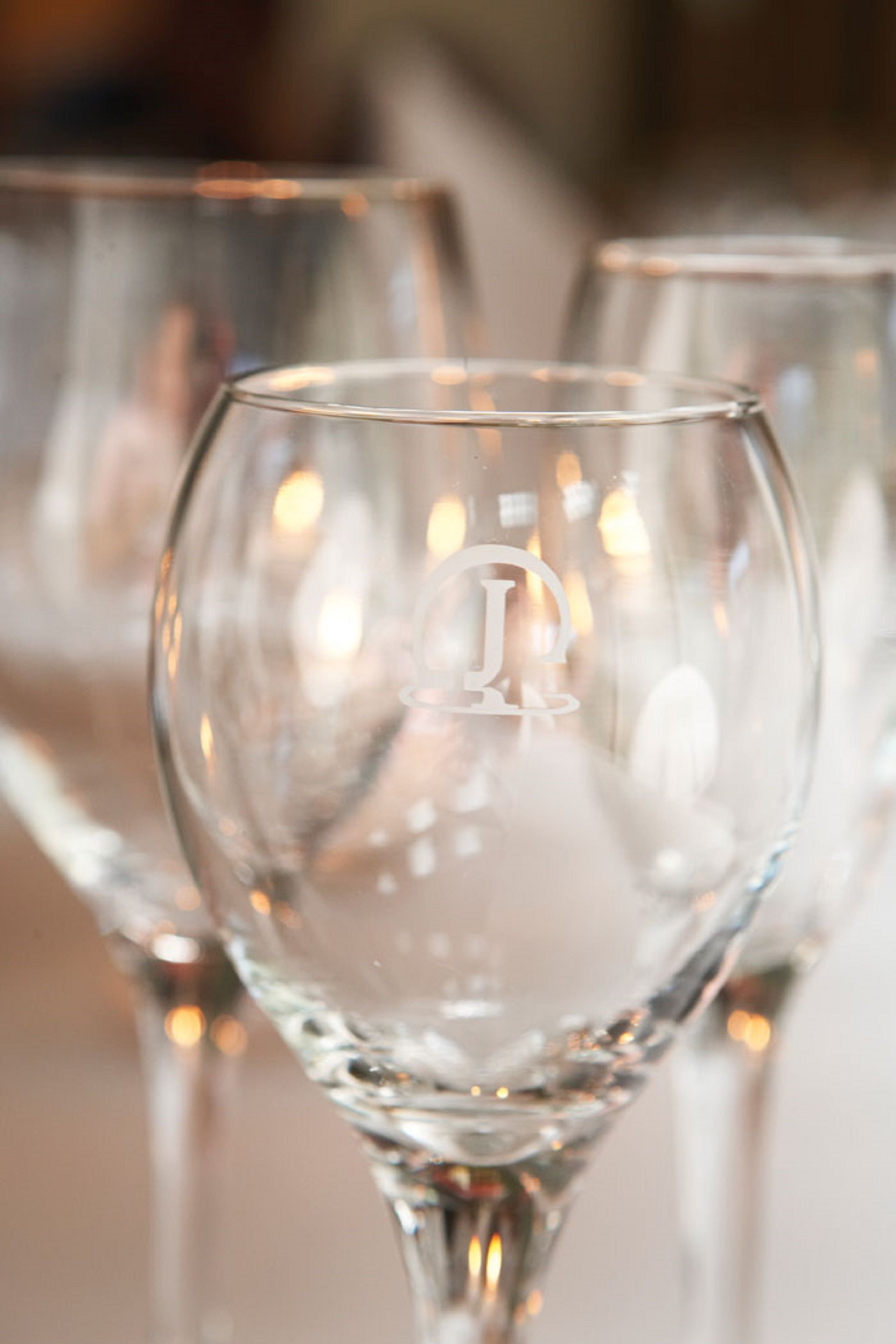 Un gros plan d’un verre transparent orné d’un logo, faisant partie d’une rangée de verres similaires.