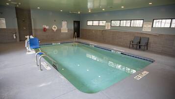 Una piscina techada, sillones reclinables de piscina
