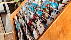 A display of travel maps and guides in a wooden stand. - Travelodge by Wyndham Valleyfair Shakopee (Shakopee)