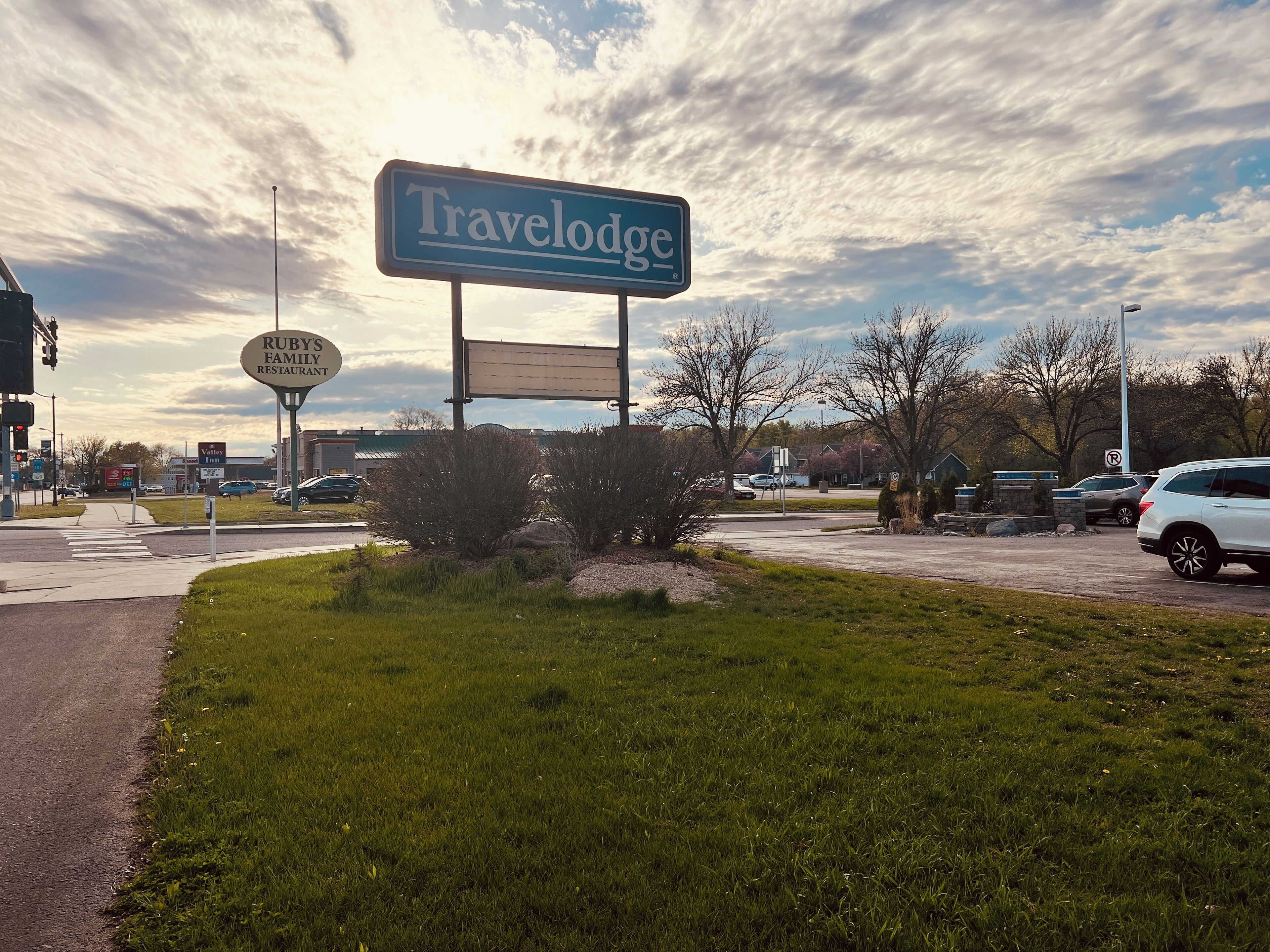 A Travelodge sign, a Ruby's Family Restaurant sign, and a Valet Inn sign.