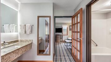 Un baño de hotel con lavamanos, espejo y perchero para toallas.