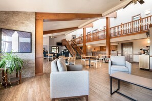 Eine großzügige Lobby mit Treppe, Sitzgelegenheiten und Blick auf die oberen Stockwerke.