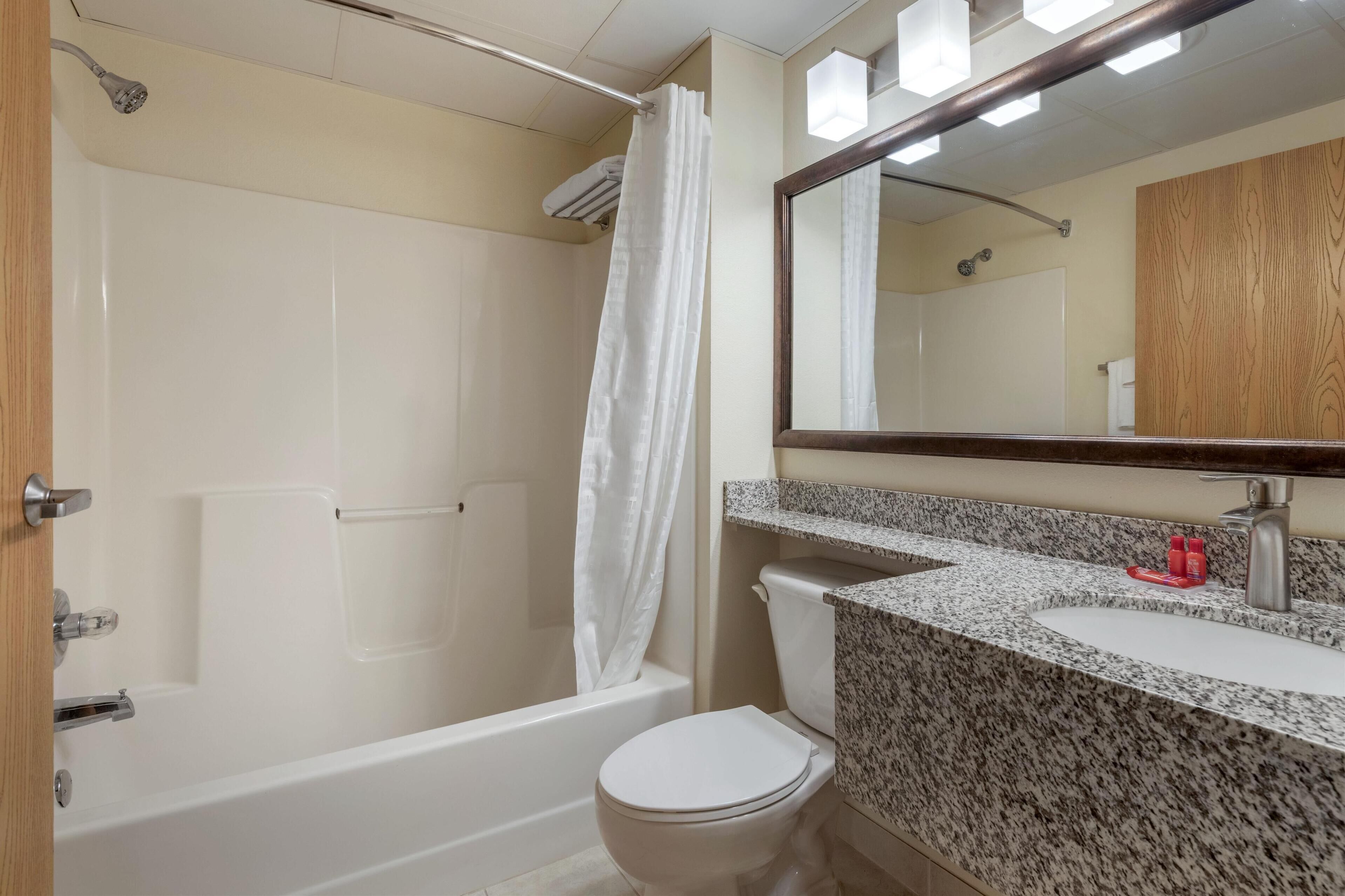 A bathroom with a bathtub, toilet, and sink.
