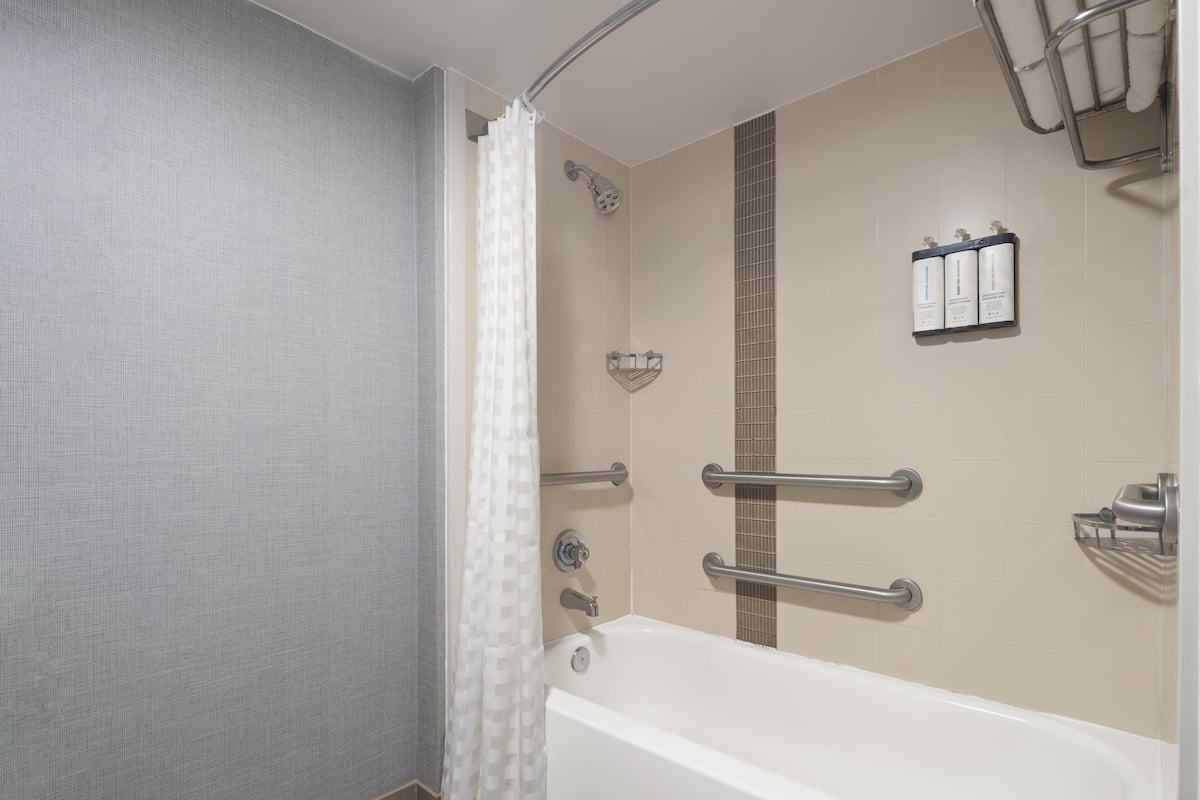 Een bad/douchecombinatie, designer toiletartikelen, een haardroger