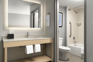 Bañera con ducha, artículos de tocador de diseñador, secador de pelo