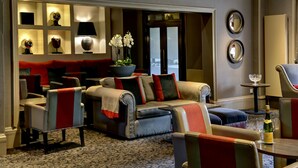 A modern living room with a sofa, chairs, a coffee table, and a decorative bowl with flowers. - Best Western Garfield House Hotel (Glasgow)