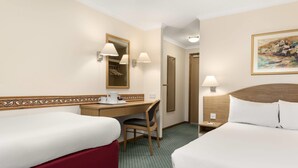 A hotel room with two beds, a desk with a chair, a mirror, and a painting on the wall. - Days Inn by Wyndham Donington A50 (Derby)