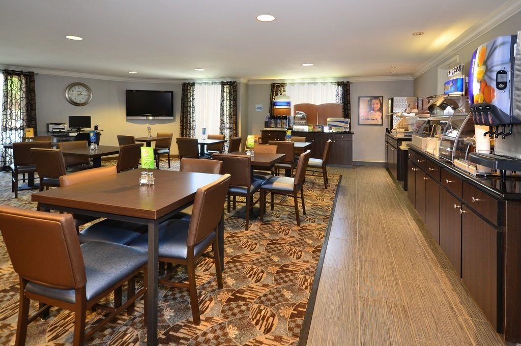 A hotel room with a dining area, a kitchen, and a TV.