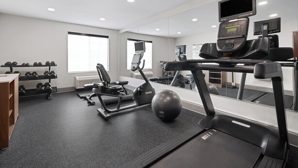 A modern gym with exercise equipment, a treadmill, and a mirrored wall. - Holiday Inn Exp Winston Salem by IHG (Winston-Salem)