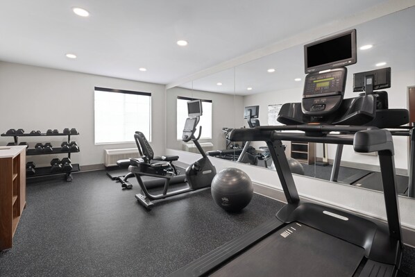 A modern gym with exercise equipment, a treadmill, and a mirrored wall. - Holiday Inn Exp Winston Salem by IHG (Winston-Salem)