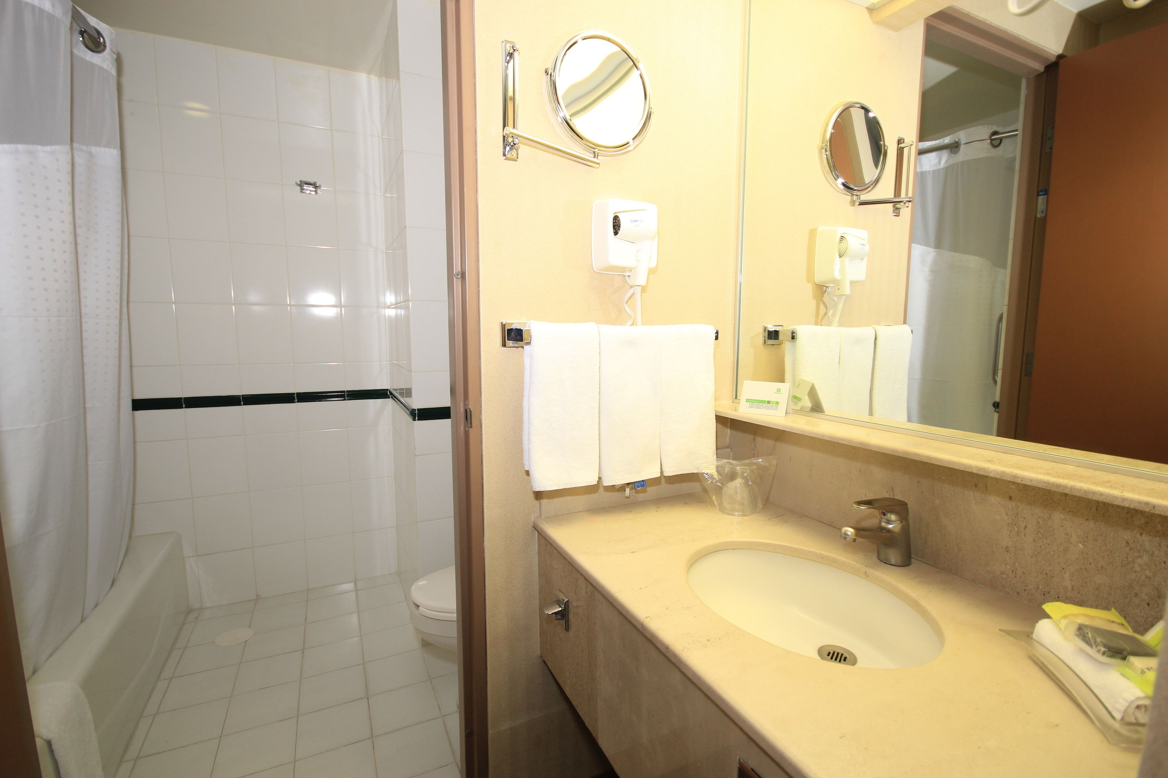 A bathroom with a white sink, mirror, and towel rack.