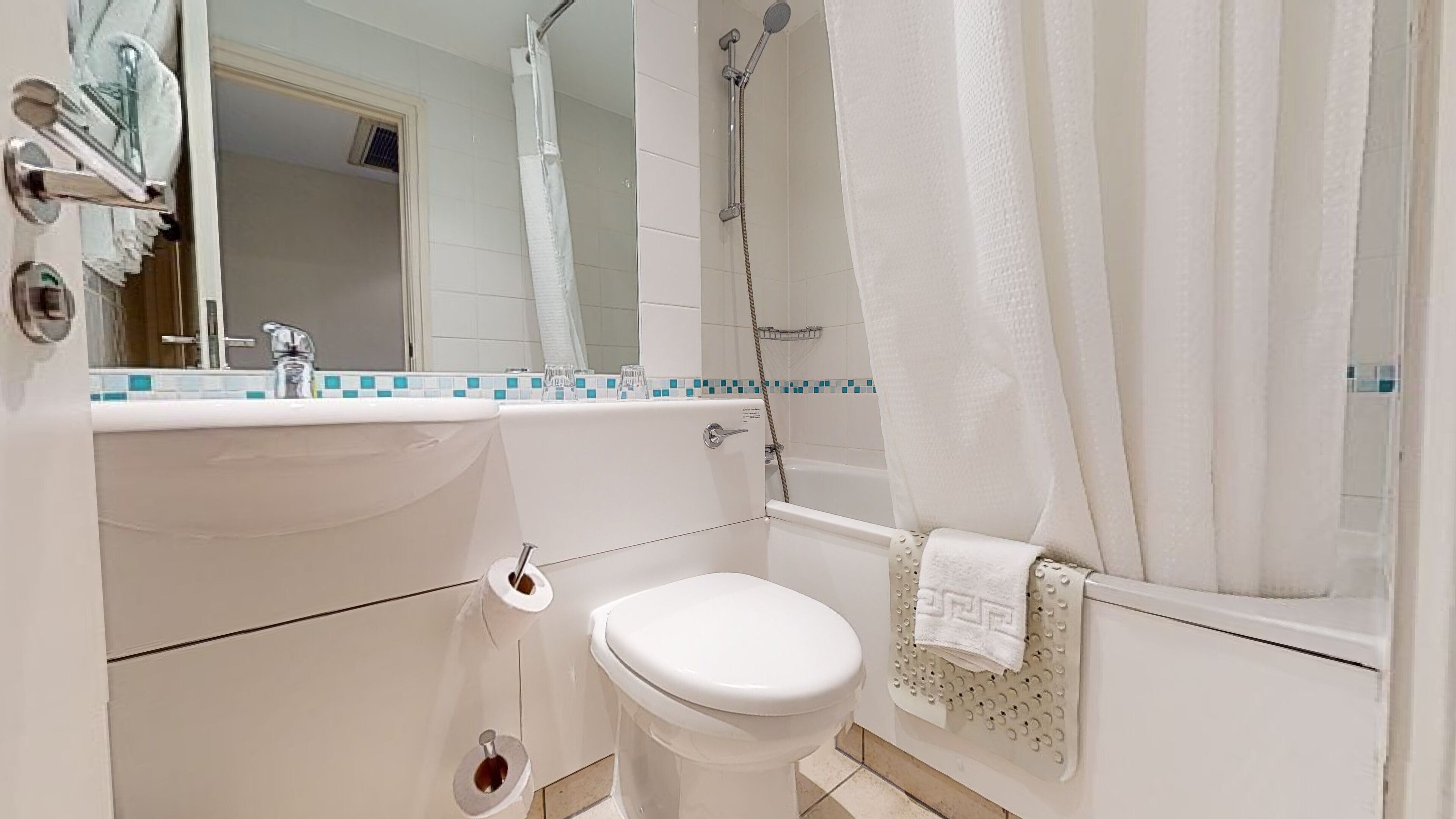 A bathroom with a toilet, sink, and shower.