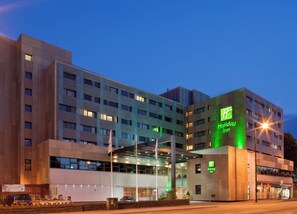 A multi-story Holiday Inn hotel with a modern facade, large windows, and a prominent green logo. - Holiday Inn Cardiff City Centre by IHG (Cardiff)