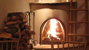 A dining table set for a meal with a fireplace in the background. - The Hacienda & Spa at Hotel Santa Fe (Santa Fe)