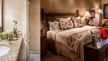 A bathroom with a granite sink, mirror, and potted plants. The room has a wooden headboard bed with a patterned bedspread and pillows. There is a nightstand with a lamp and a small table with a vase.
