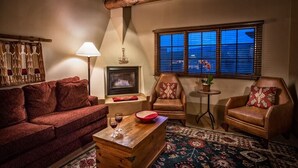 A cozy living room with a fireplace, two leather armchairs, a wooden coffee table, and a patterned rug. - The Hacienda & Spa at Hotel Santa Fe (Santa Fe)