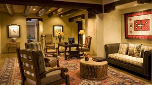 A cozy living room with a sofa, chairs, a coffee table, and a fireplace. - The Hacienda & Spa at Hotel Santa Fe (Santa Fe)