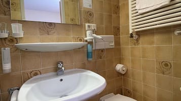 A bathroom with a sink, toilet, and towel rack.