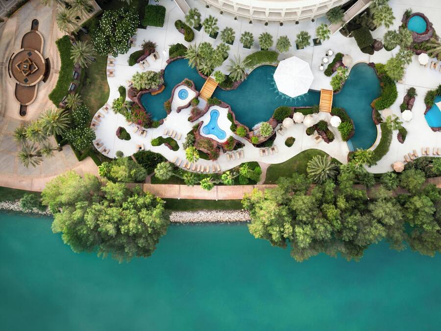 Una piscina techada, una piscina al aire libre, sombrillas