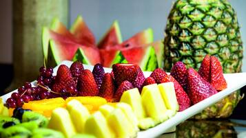 Une variété de fruits, notamment des fraises, des raisins, des kiwis et des ananas, disposés sur une assiette blanche.