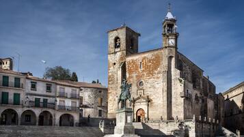 Una iglesia histórica con un campanario y una estatua en primer plano.