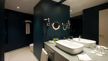 A modern bathroom with two sinks, a large mirror, and a towel rack.