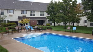 Relax by the pool surrounded by lush greenery and a charming outdoor space.
