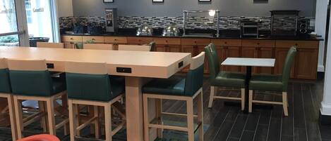 Un restaurante con mostrador, mesas y sillas.
