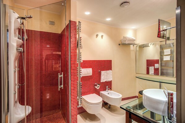 Ein modernes Badezimmer mit Duschkabine aus Glas, Waschbecken aus Glas und einer weißen Toilette.