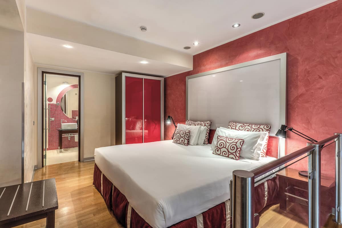 Relax in a spacious room with a large bed, flat-screen TV, and a separate bathroom with a shower area.