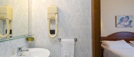 A bathroom with a sink, mirror, towel rack, and a shower with a handheld showerhead.