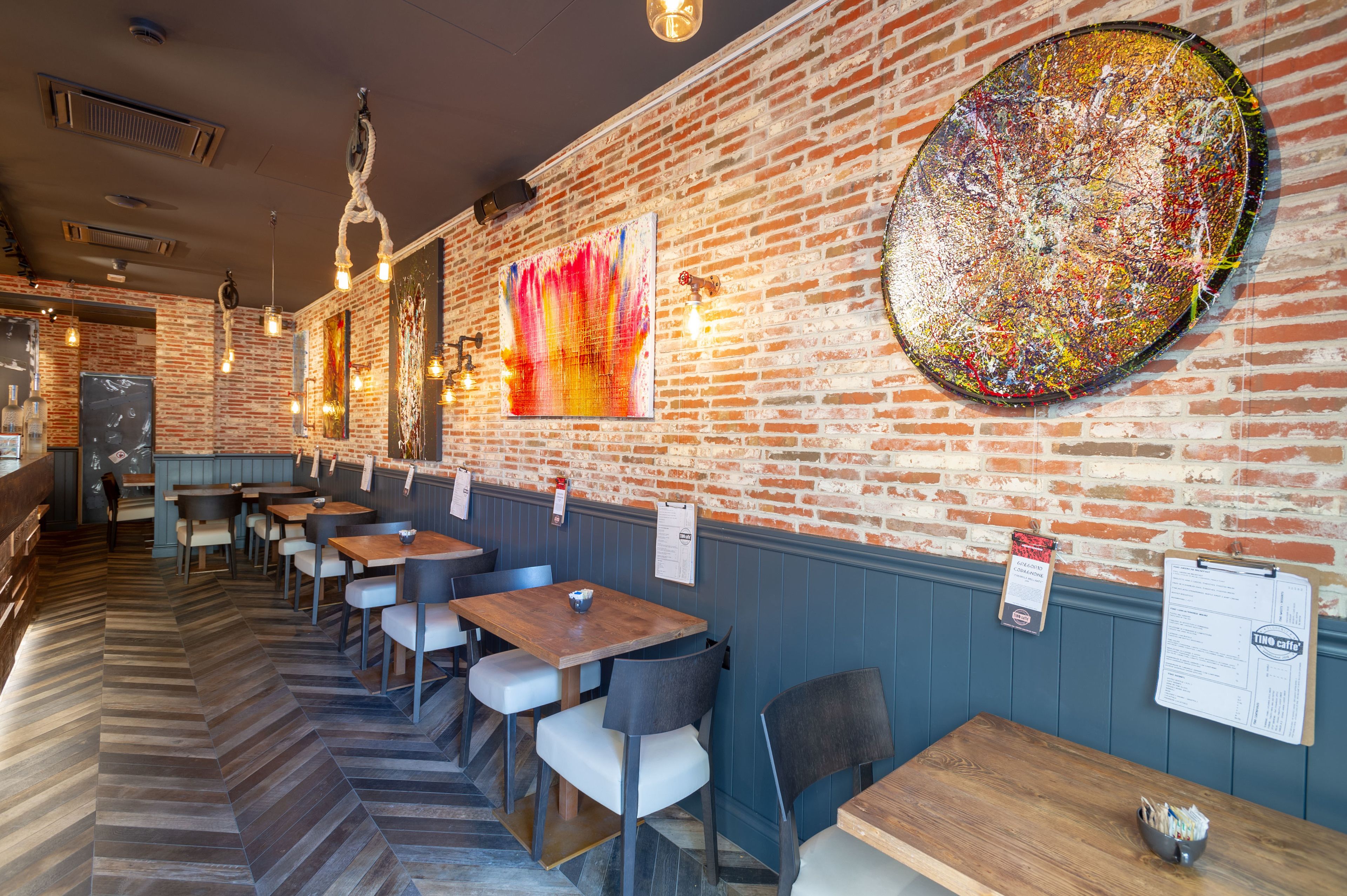 Un restaurante con paredes de ladrillo, mesas y sillas de madera.